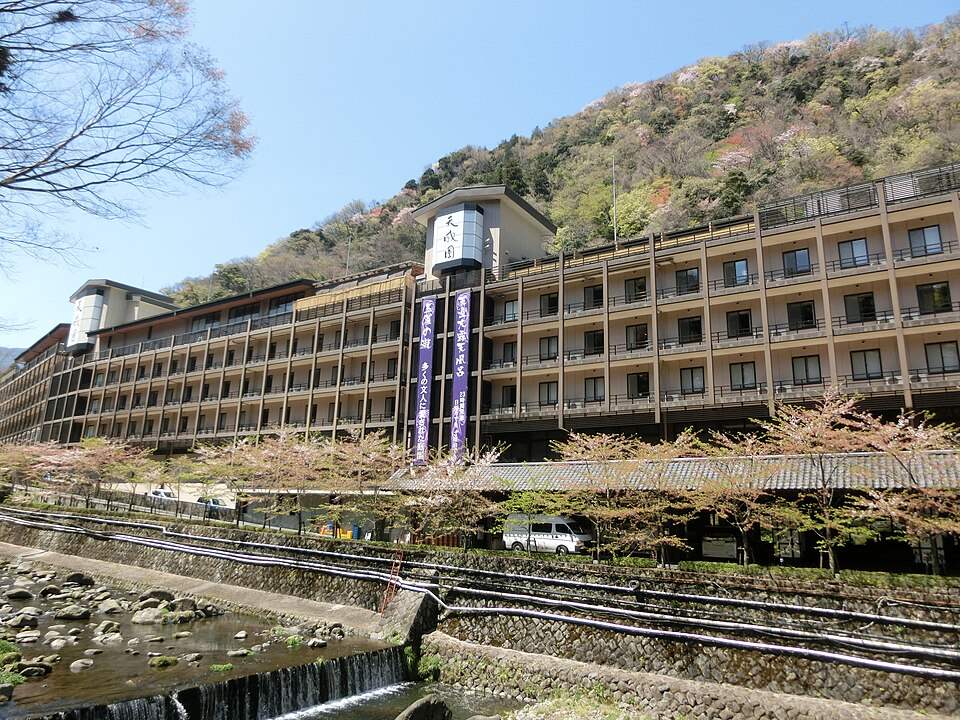 天成園の外観と手前の川沿いの桜