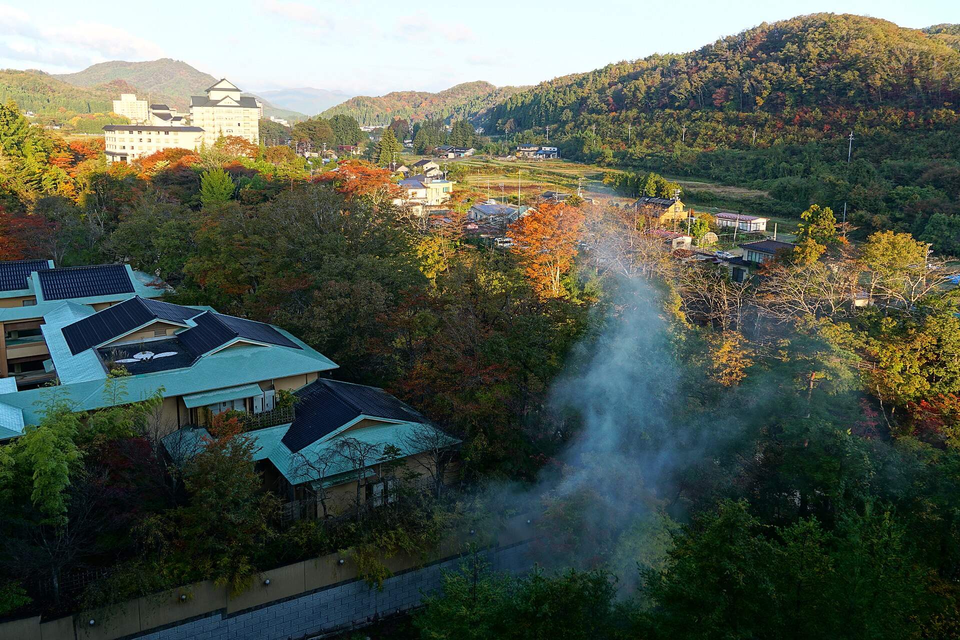 紅葉の秋保温泉。旅館の屋根と立ちのぼる湯けむり