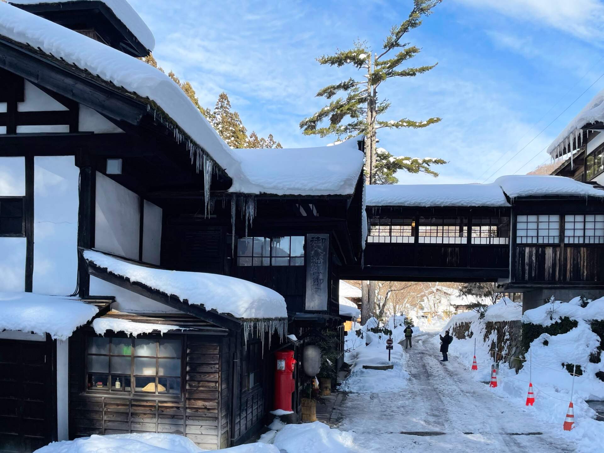 雪に覆われた法師温泉長寿館の木造の建物と渡り廊下
