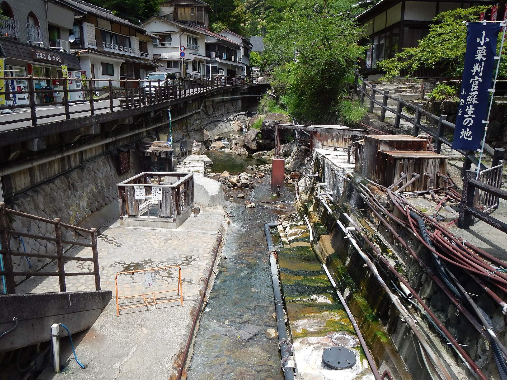 湯の峰温泉の川沿いの湯筒と、谷に並ぶ宿
