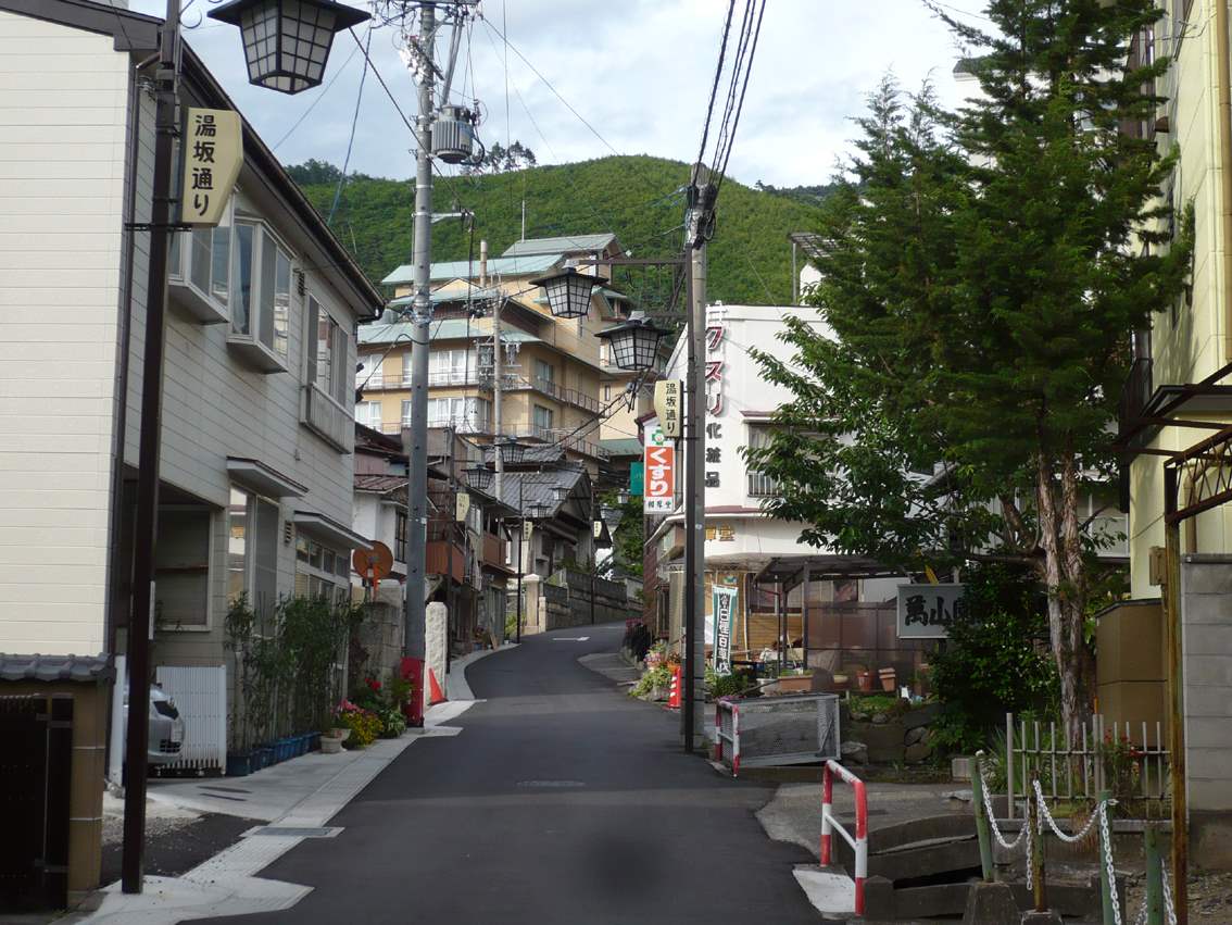 「温泉通り」の看板が立つ浅間温泉の坂道の街並み
