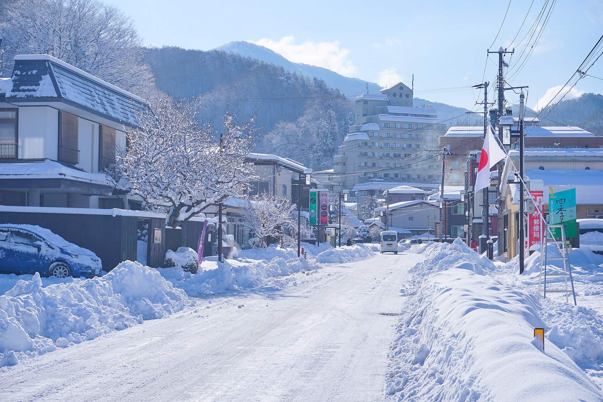 雪の積もった繋温泉の温泉街の通りと旅館の建物