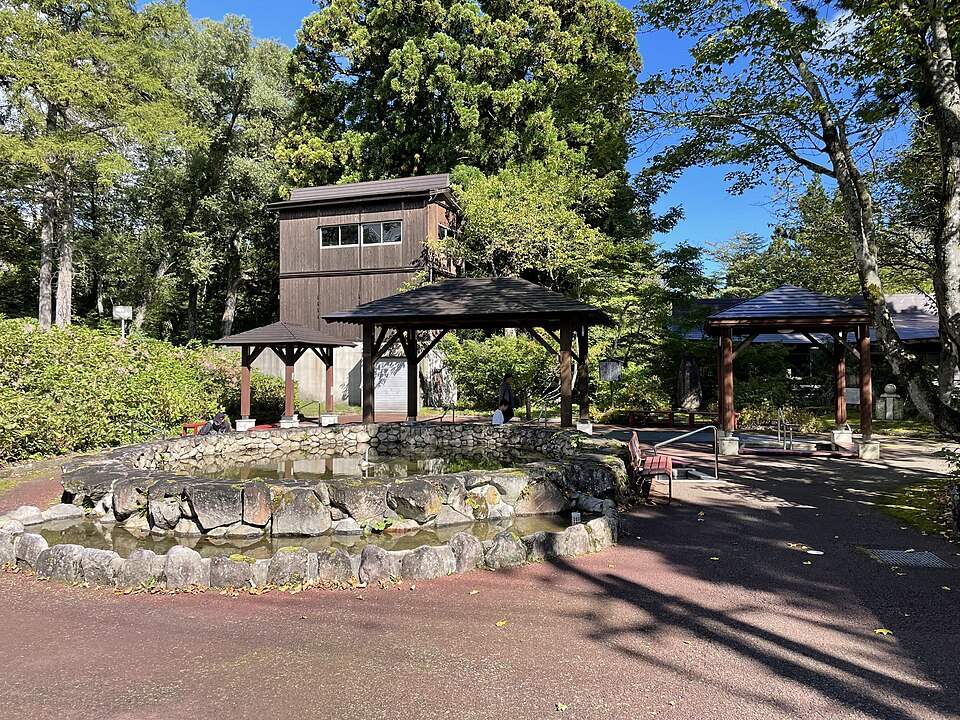 赤倉温泉の足湯公園。木立の中に石造りの足湯とあずまや