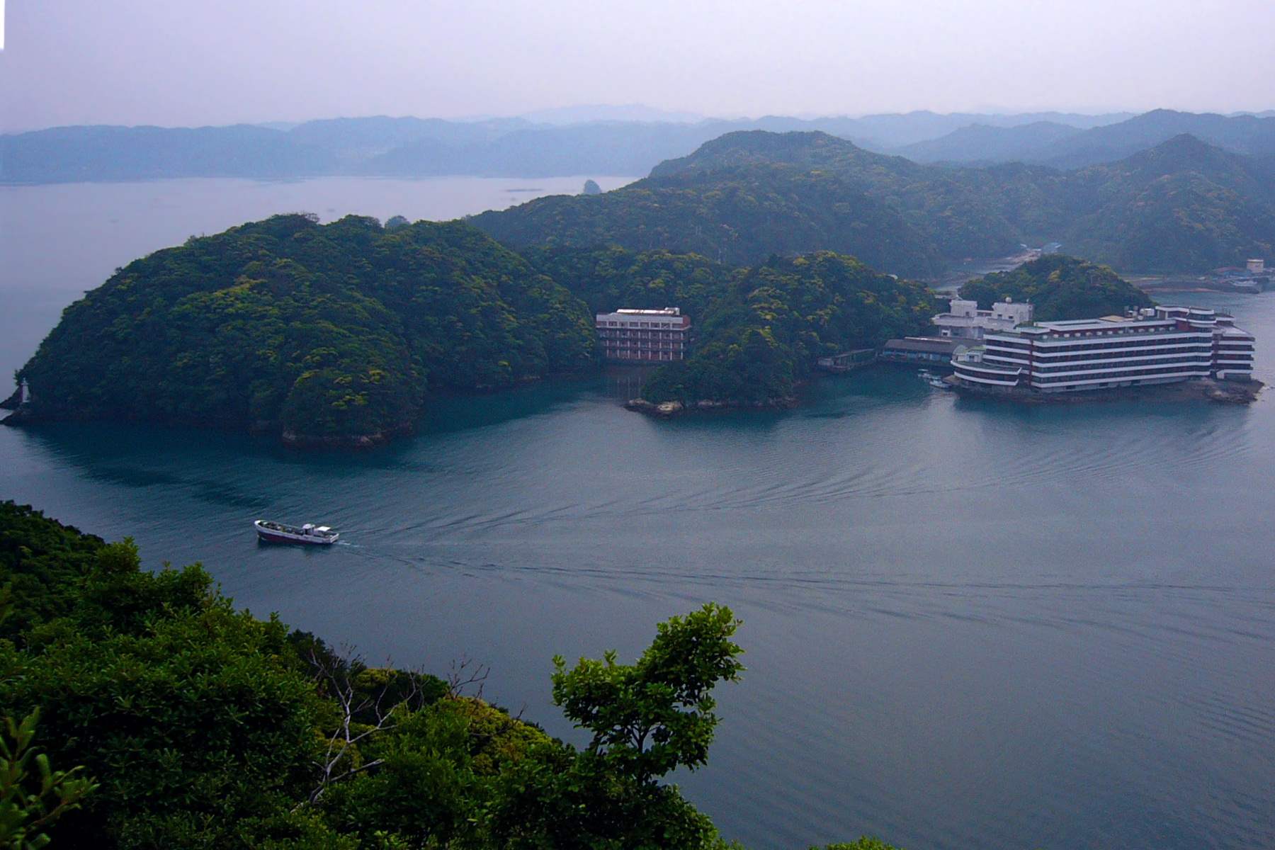 入り江に面した南紀勝浦温泉の旅館と、湾を行く船