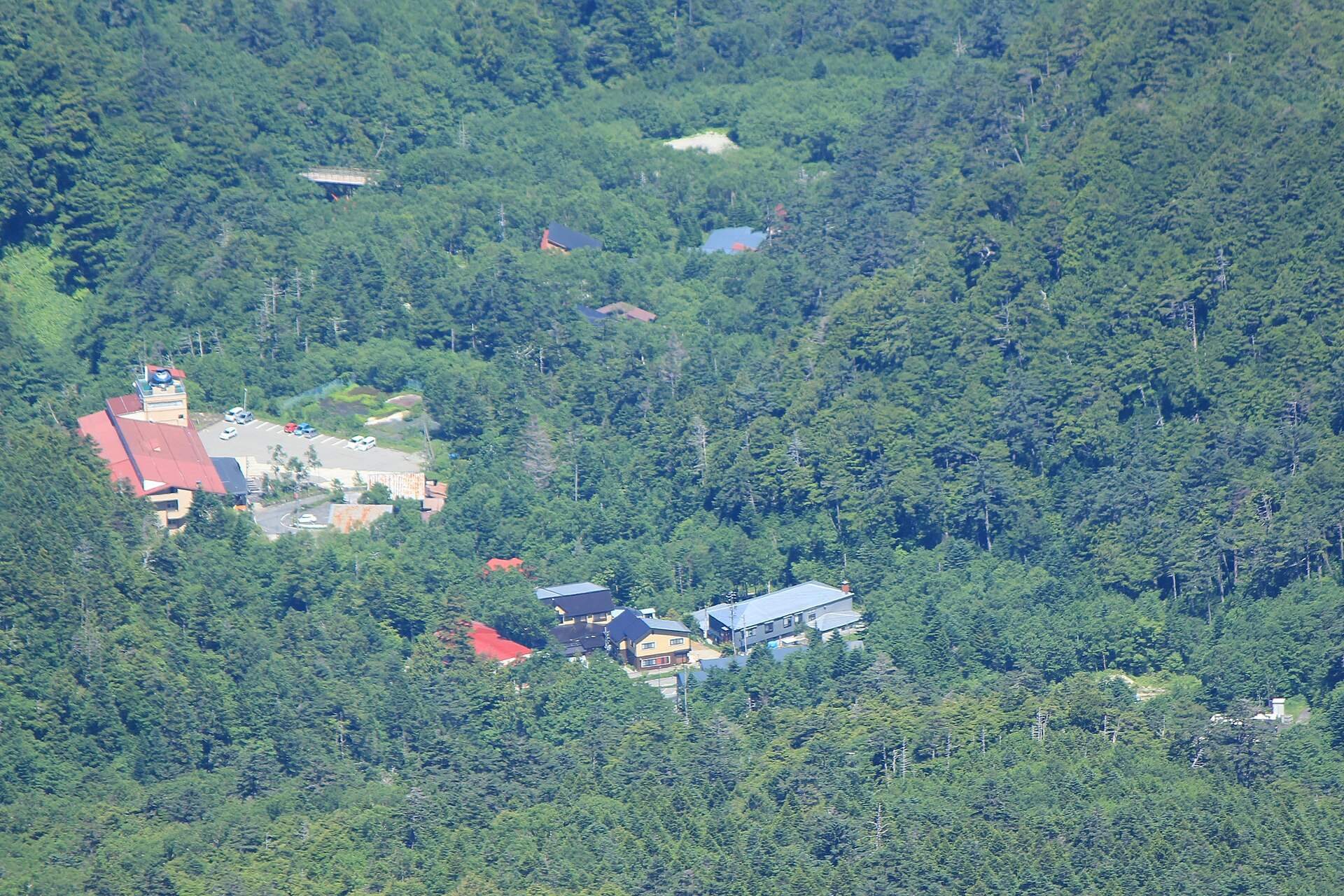 御嶽山の摩利支天山から見下ろした、森の中の濁河温泉の宿