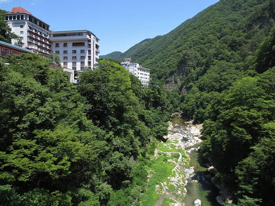 片品川の渓谷と、崖の上に建つ老神温泉のホテル