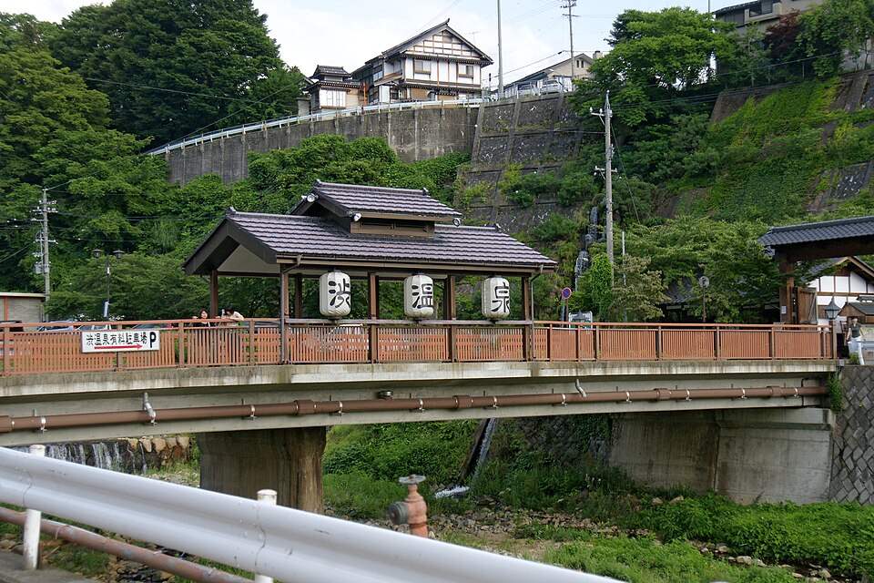「渋温泉」の提灯を下げた橋の上のあずまやと温泉街