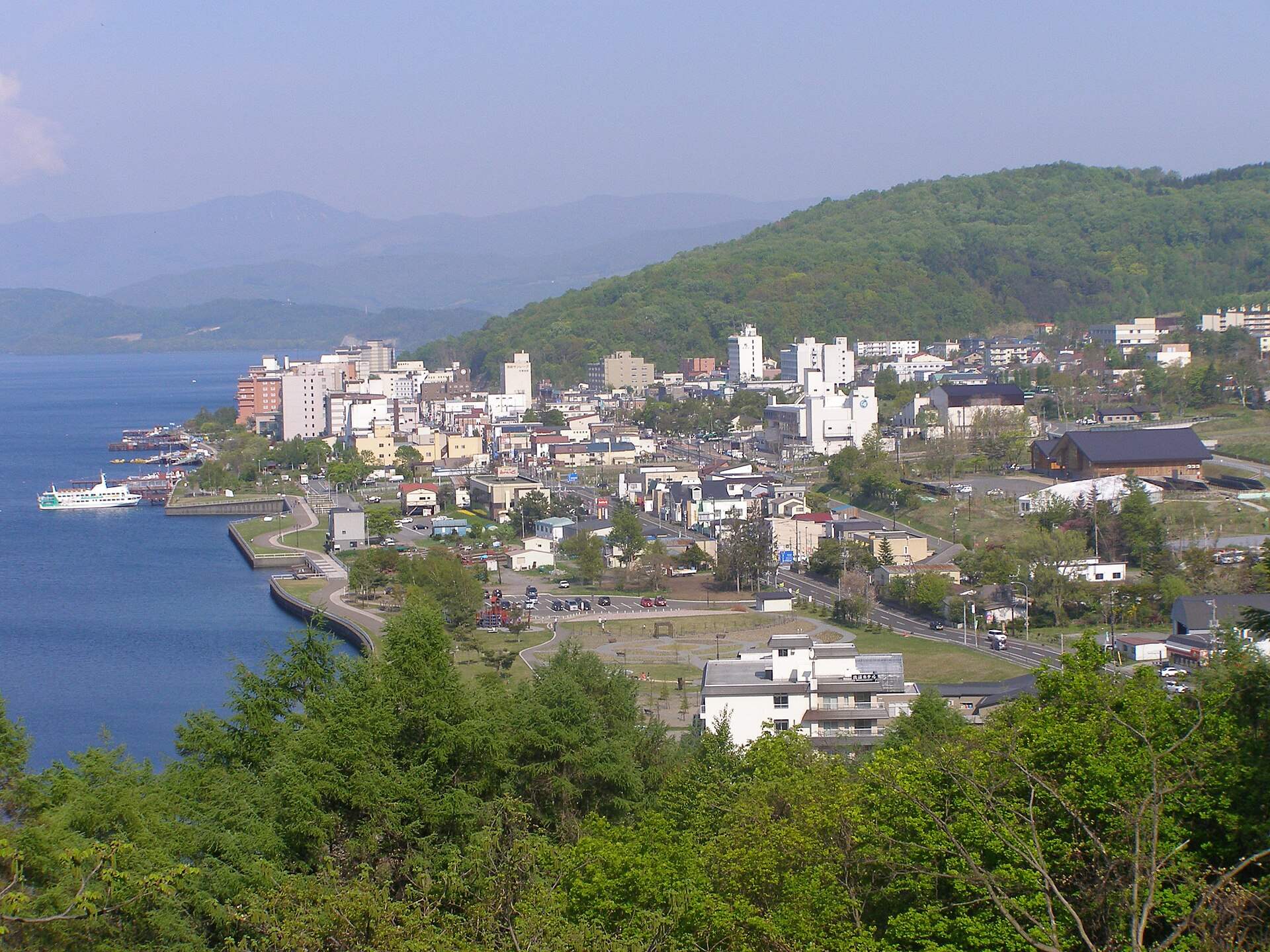 高台から見た洞爺湖温泉の街並みと湖畔に並ぶホテル