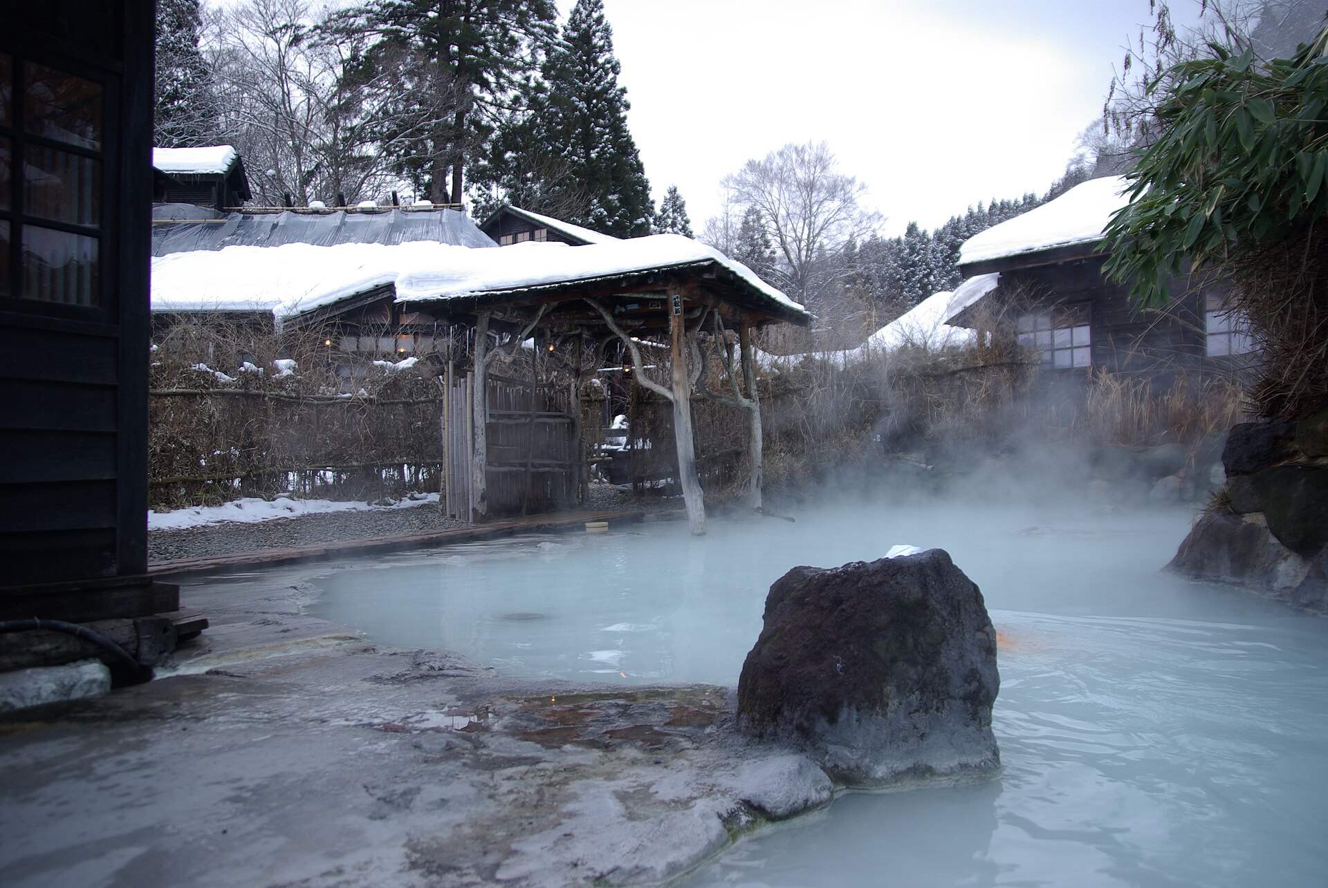 雪の鶴の湯温泉の乳白色の露天風呂と湯けむり