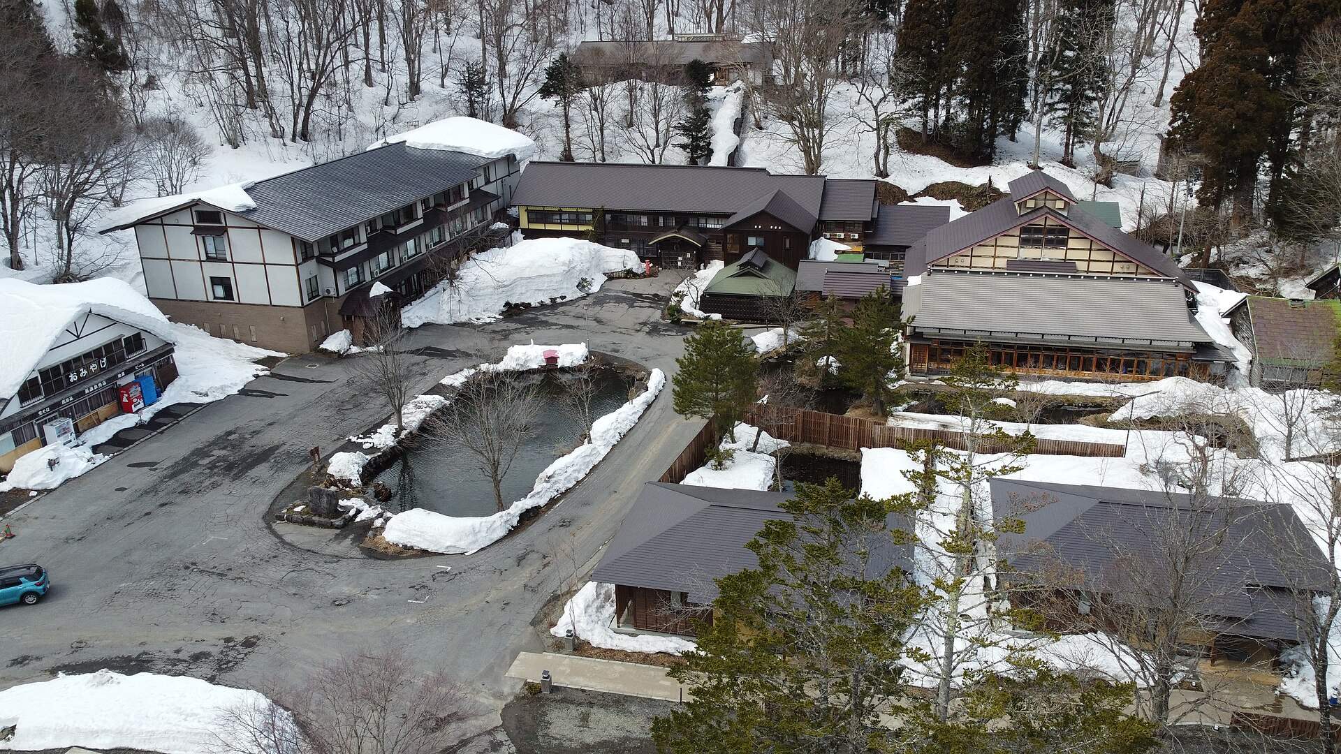 雪の残るブナの森に建つ蔦温泉の旅館(上空から)