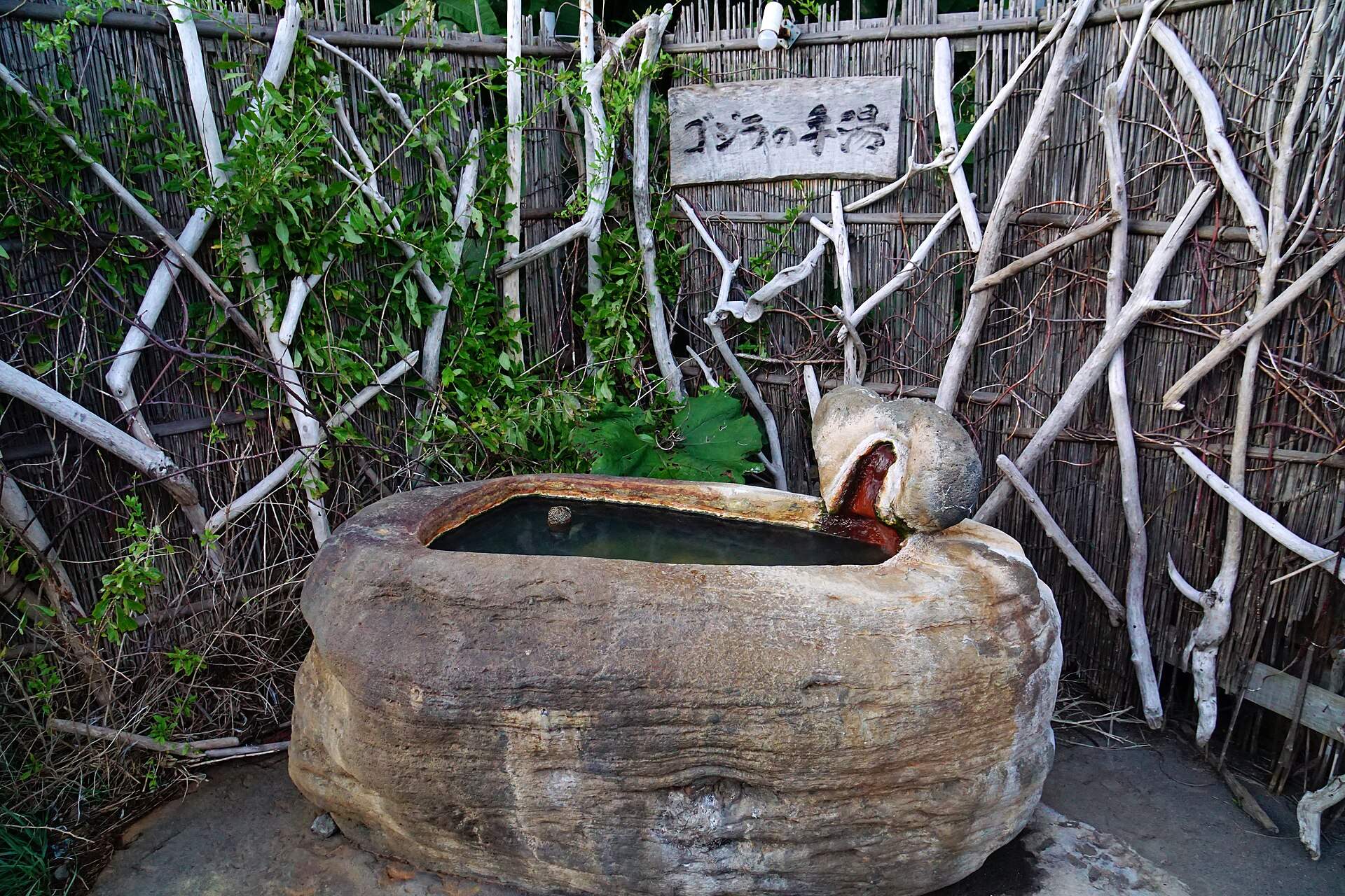 ウトロ温泉の手湯「ゴジラの手湯」。岩をくりぬいた湯船に湯が注ぐ