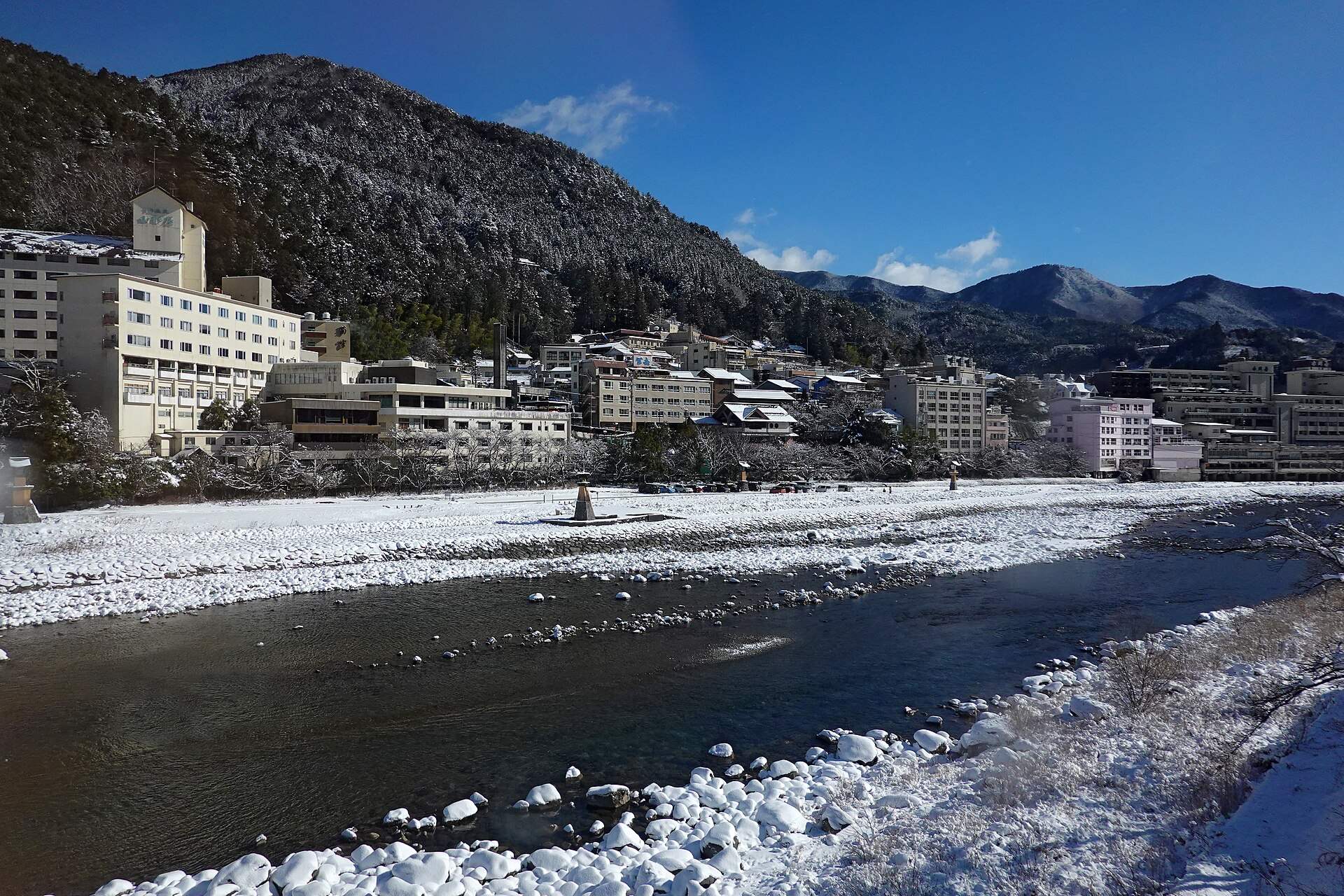 雪の河原の飛騨川と、対岸に並ぶ下呂温泉の旅館・ホテル(2026年1月)