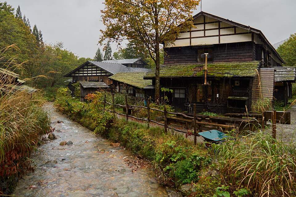 紅葉の中、小川沿いに建つ乳頭温泉郷の木造の宿(2025年10月)