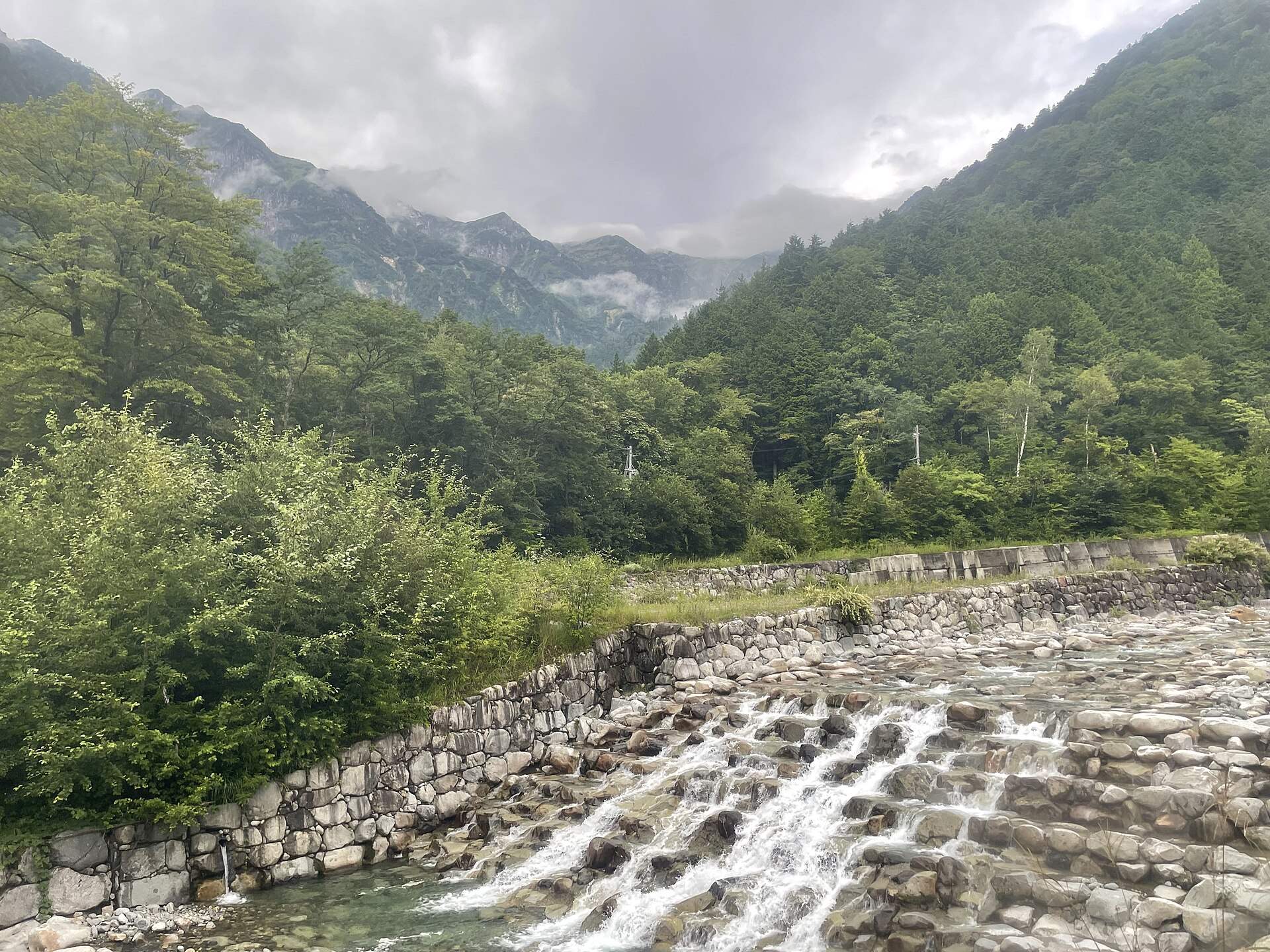 新穂高温泉駅の近くから見た渓流と北アルプスの山並み(2026年8月)