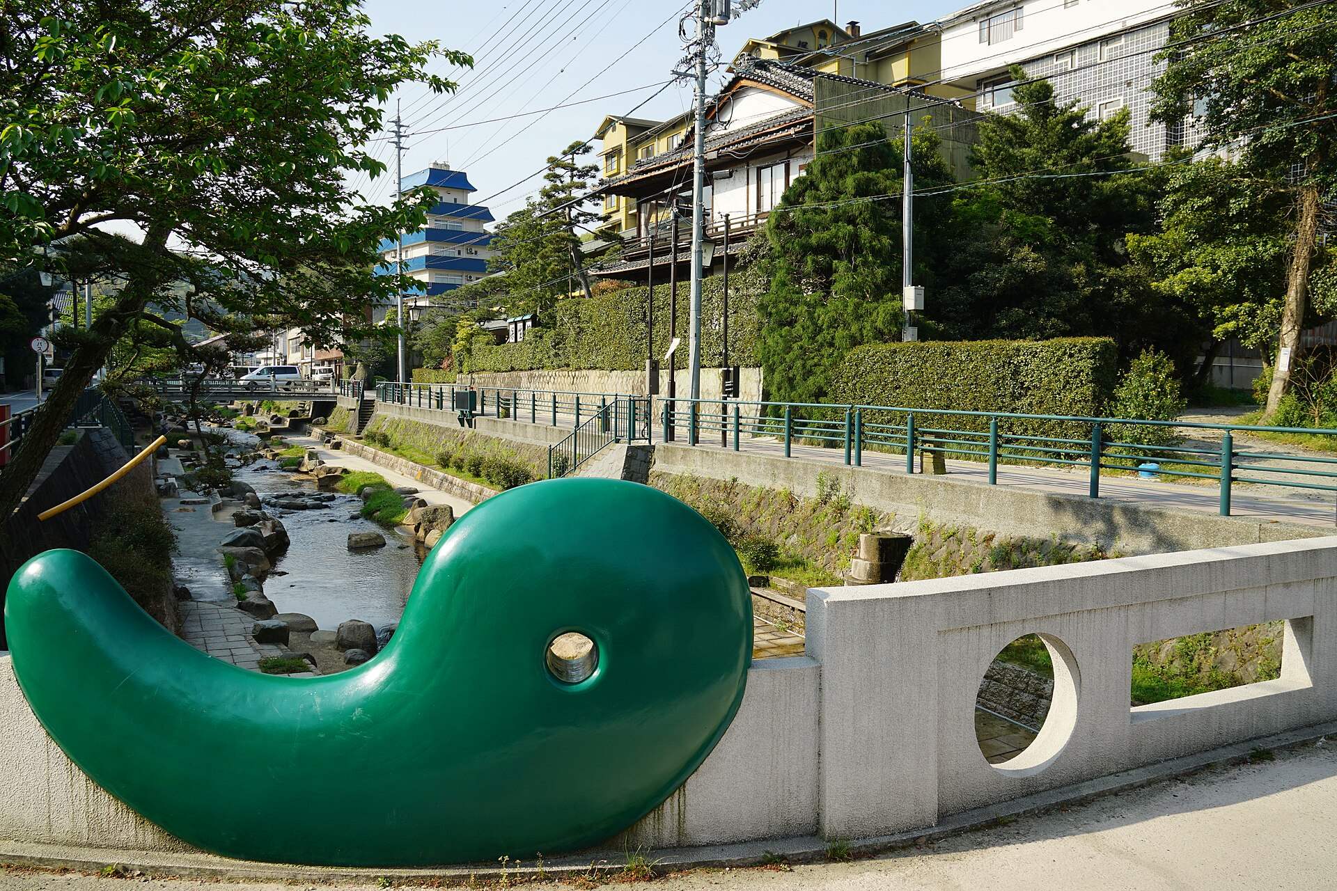 玉湯川沿いの玉造温泉の街並みと、橋のたもとの緑色のオブジェ