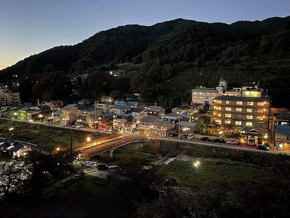 夕暮れに灯りのともる渋温泉の街並みと山(2024年10月)