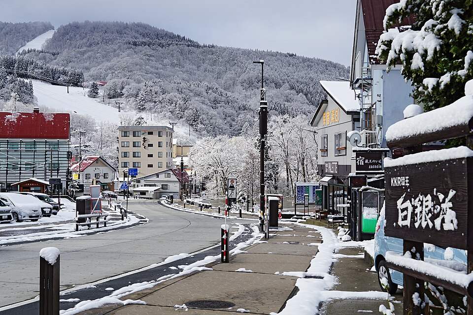 雪の残る蔵王温泉の通りと、奥のゲレンデの山(2022年4月)